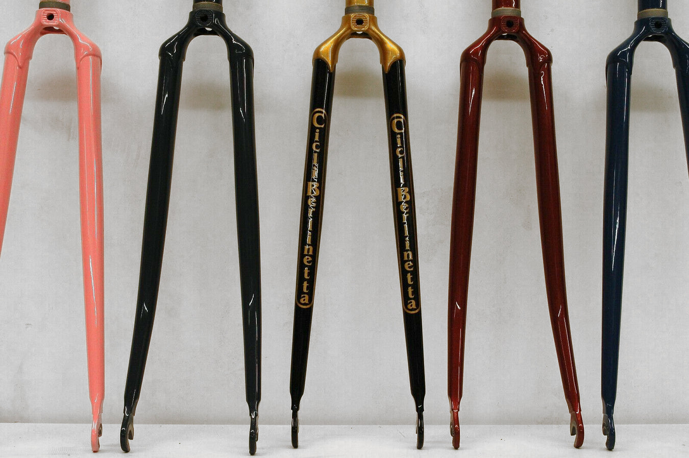 Various styles of bicycle forks in different colours.